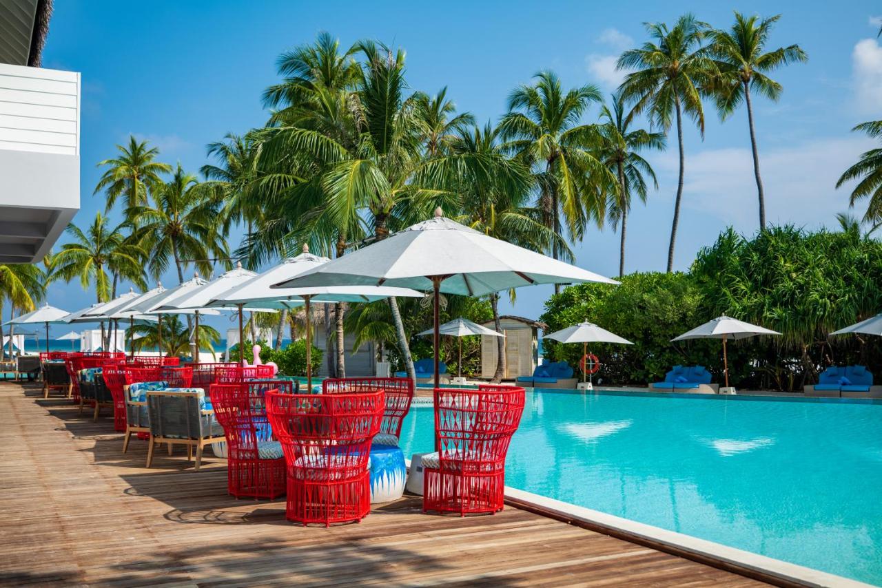 Finolhu Baa Atoll Maldives - piscina infinita, cadeiras de vime vermelhas no resort de luxo nas Ilhas Maldivas