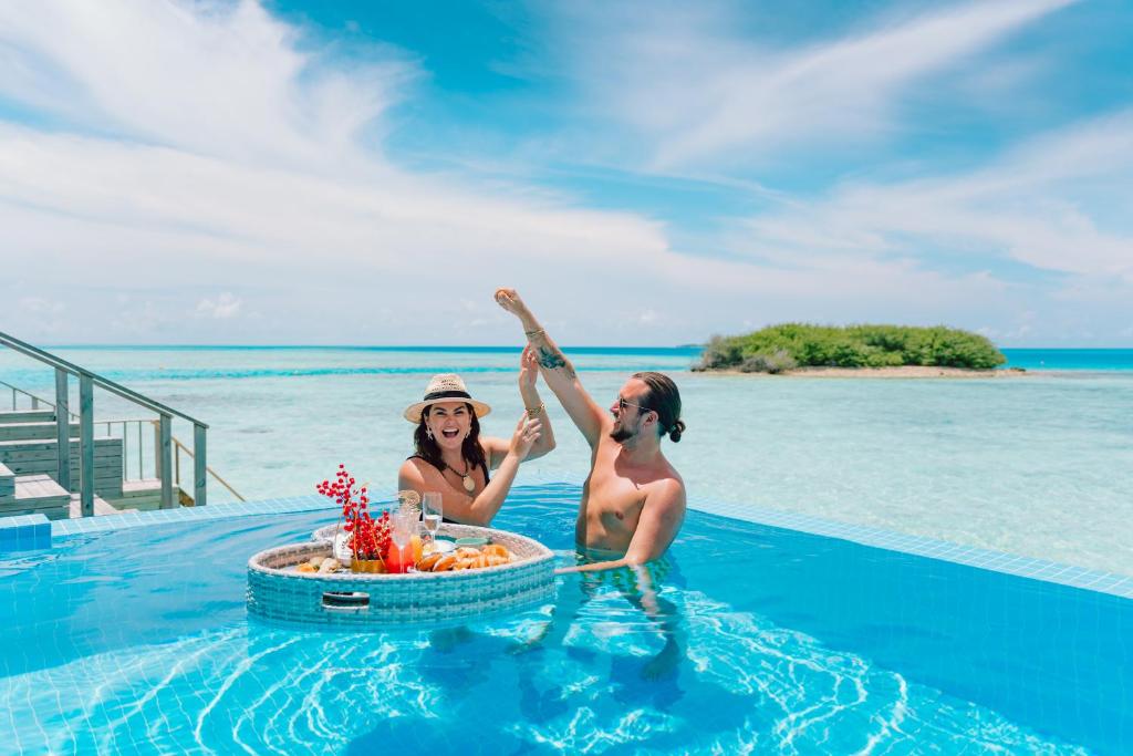 NOOE Maldives Kunaavashi - piscina infinita, casal no resort de luxo nas Ilhas Maldivas