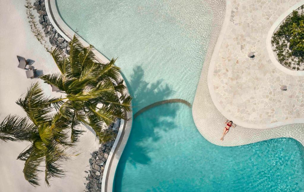 Patina Maldives - água turquesa, palmeiras no resort de luxo nas Ilhas Maldivas