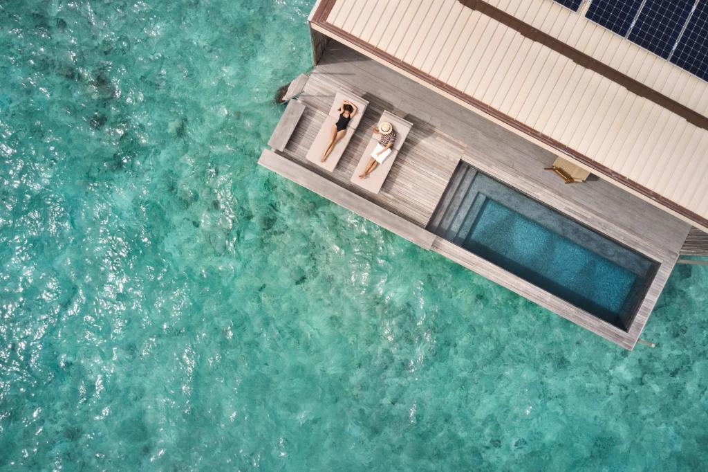 Patina Maldives - piscina infinita, espreguiçadeiras no resort de luxo nas Ilhas Maldivas