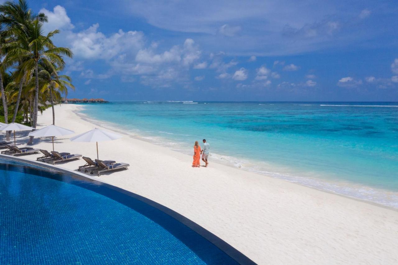 Radisson Blu Resort Maldives - piscina infinita, casal caminhando no resort de luxo nas Ilhas Maldivas
