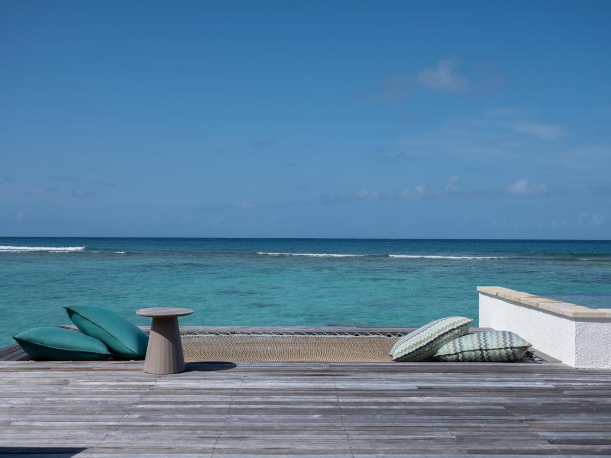 Six Senses Kanuhura - deck sobre a água, almofadas teal no resort de luxo nas Ilhas Maldivas