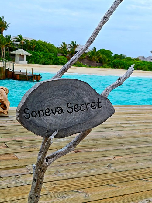 Soneva Secret - placa de madeira, água turquesa no resort de luxo nas Ilhas Maldivas